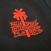 Embroidered logo of Palm Springs International Film Festival on a black background