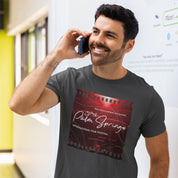 Man wearing a t-shirt with a film festival design, talking on a phone.