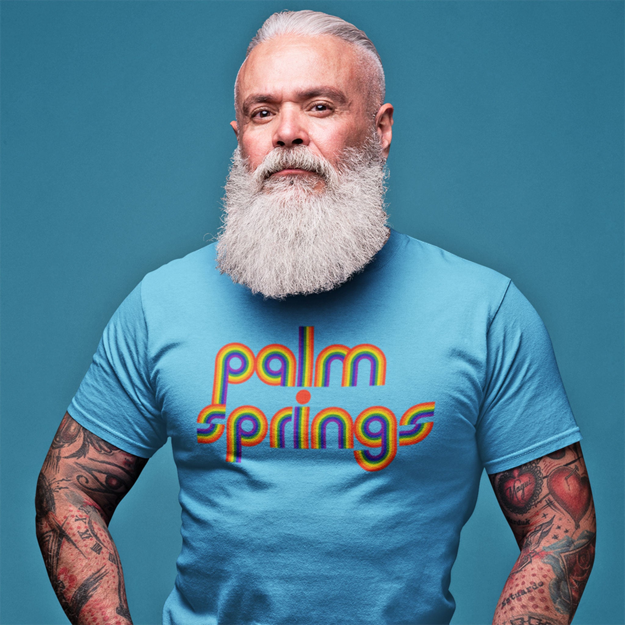 A man wearing a a blue tee shirt with Palm Springs in rainbow letters