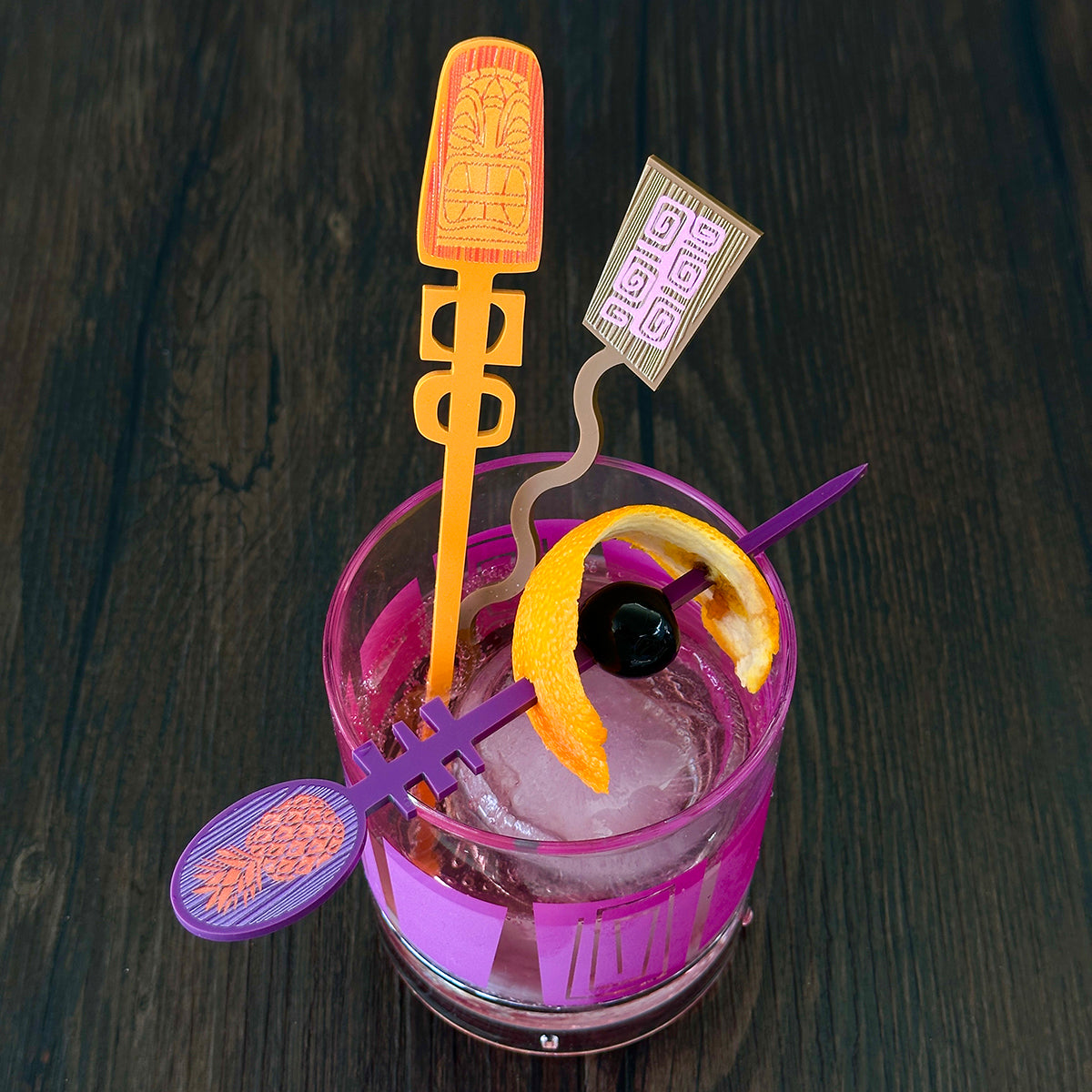 tiki design swizzle sticks in an old fashioned acrylic glass with an orange peel