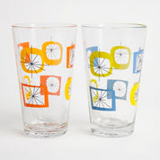 Two clear glasses with colorful geometric designs on a white background