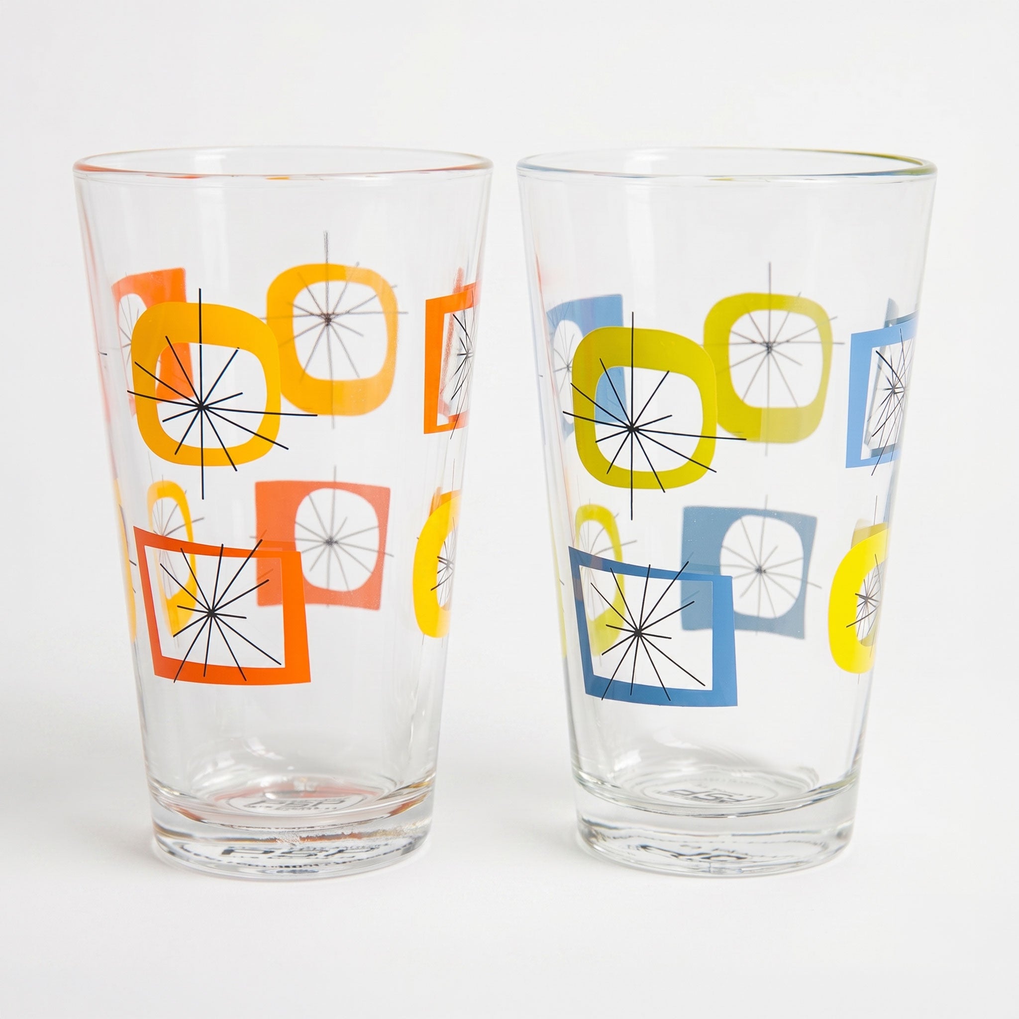 Two clear glasses with colorful geometric designs on a white background