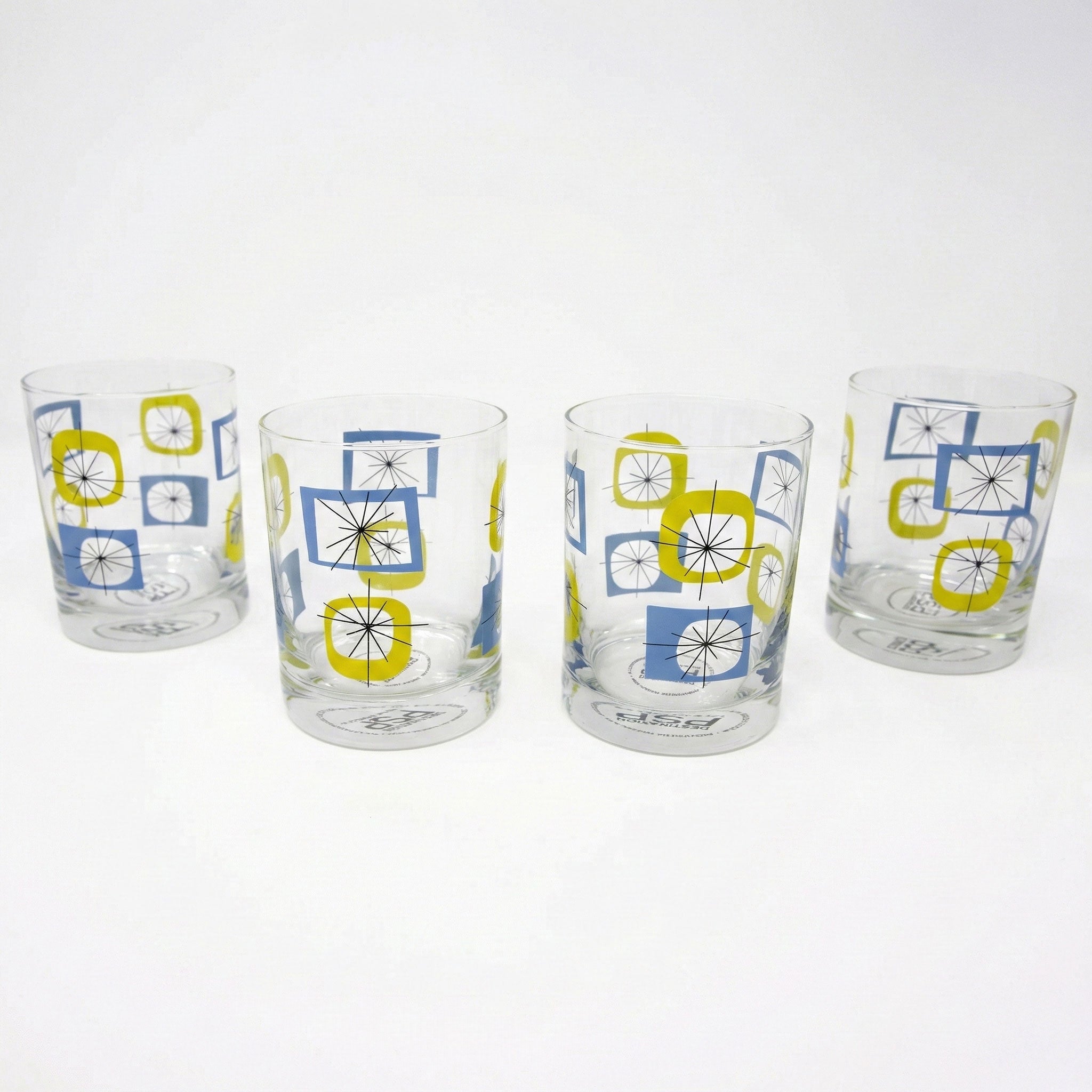 Four glass tumblers with geometric pattern on a white background