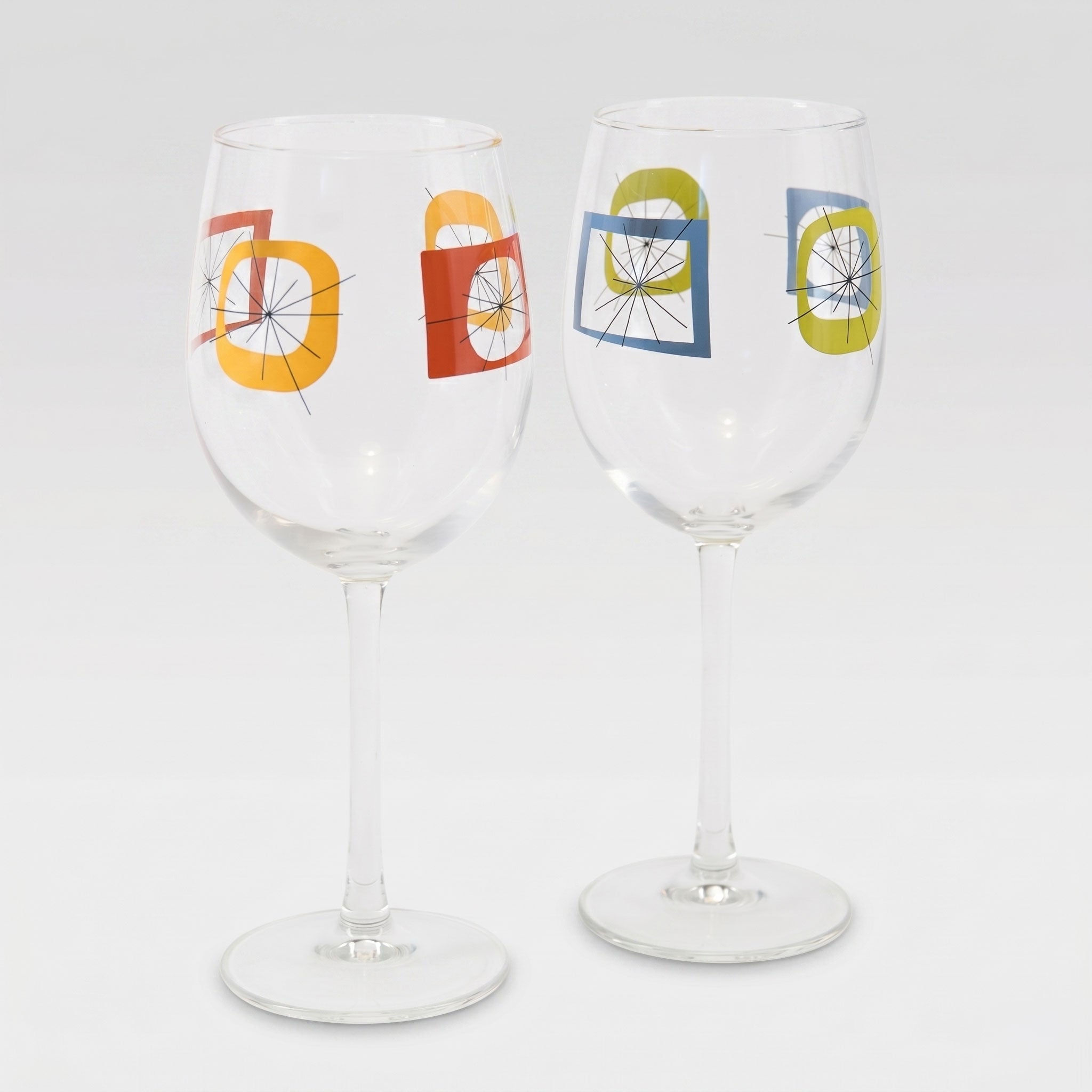 Two wine glasses with colorful geometric designs on a white background