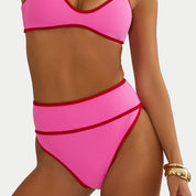 Pink bikini with red accents on a plain background