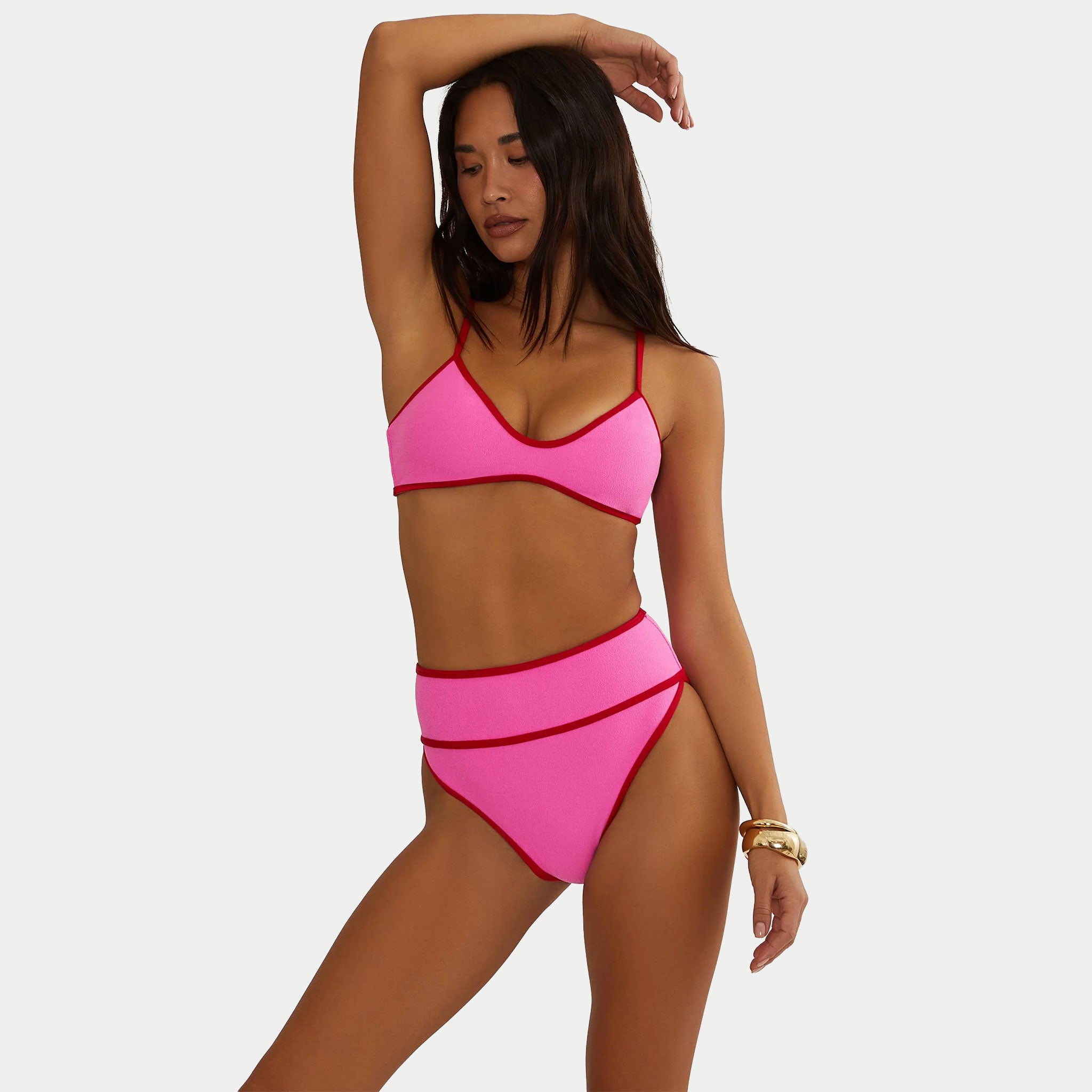 Woman wearing a pink bikini against a white background