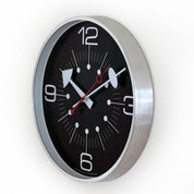 Wall clock with black face and silver frame on a white background