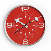 Red wall clock with white numbers and silver frame on a white background