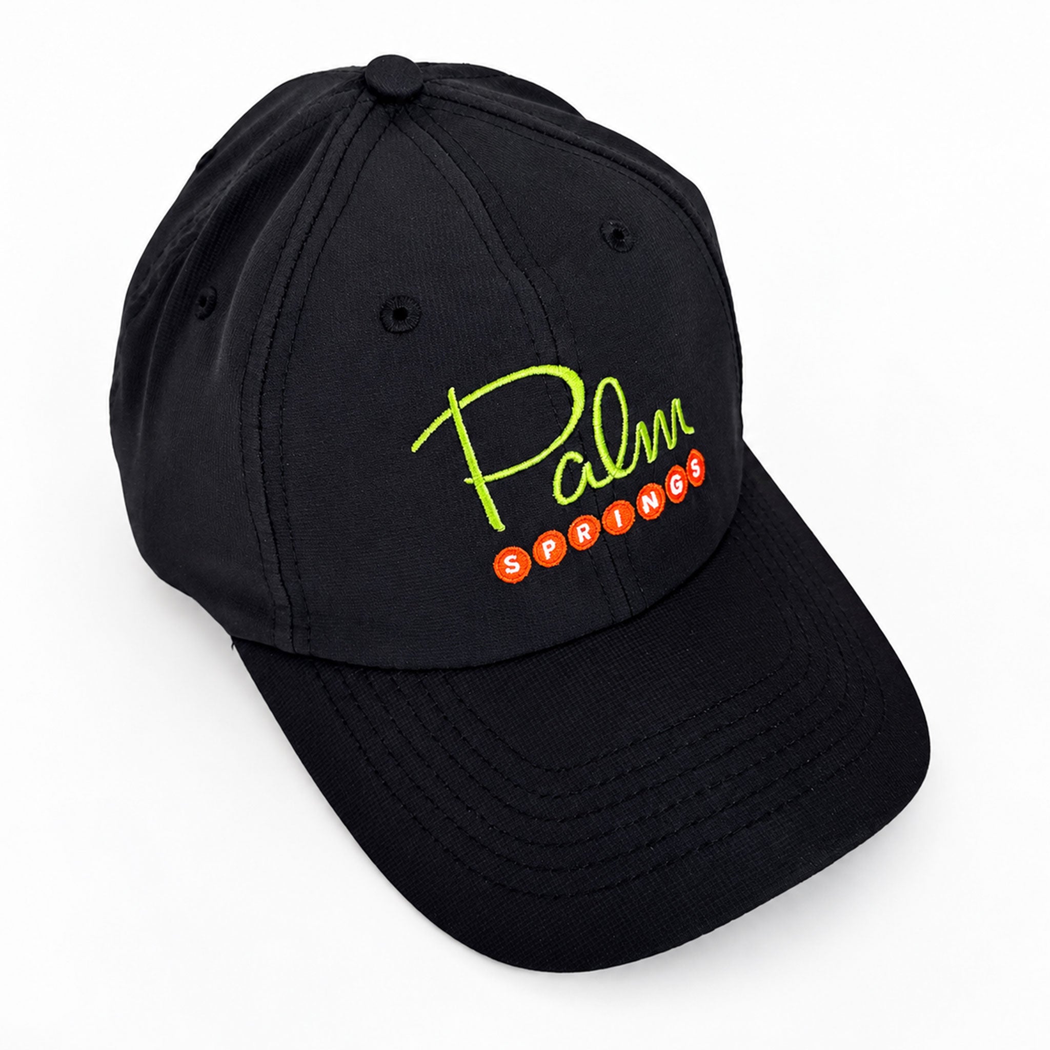A black baseball cap featuring a curved brim and embroidered 'Palm Springs' text on the front, with 'Palm' in neon yellow-green script and 'SPRINGS' in orange-red oval letters, shown on a clean white background.