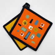 Pair of pot holders with geometric pattern on an orange background