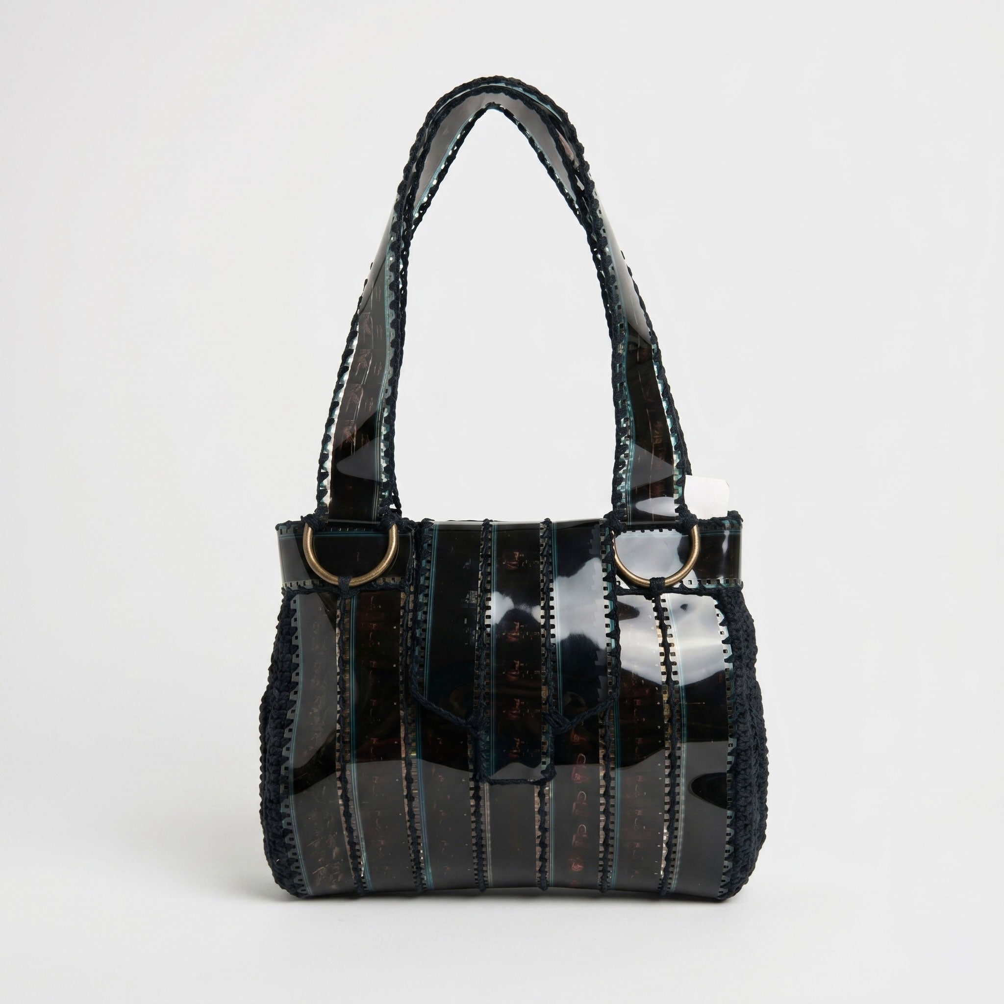 Black handbag with a shiny, reflective surface on a white background