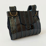 Black handbag with reflective material on a white background
