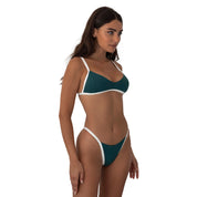 Woman wearing a teal and white bikini on a white background