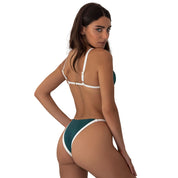 Woman wearing a green and white bikini on a white background