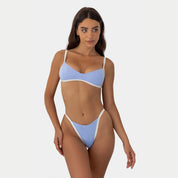 Woman wearing a light blue bikini on a white background