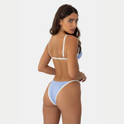Woman wearing a light blue and white bikini on a plain background