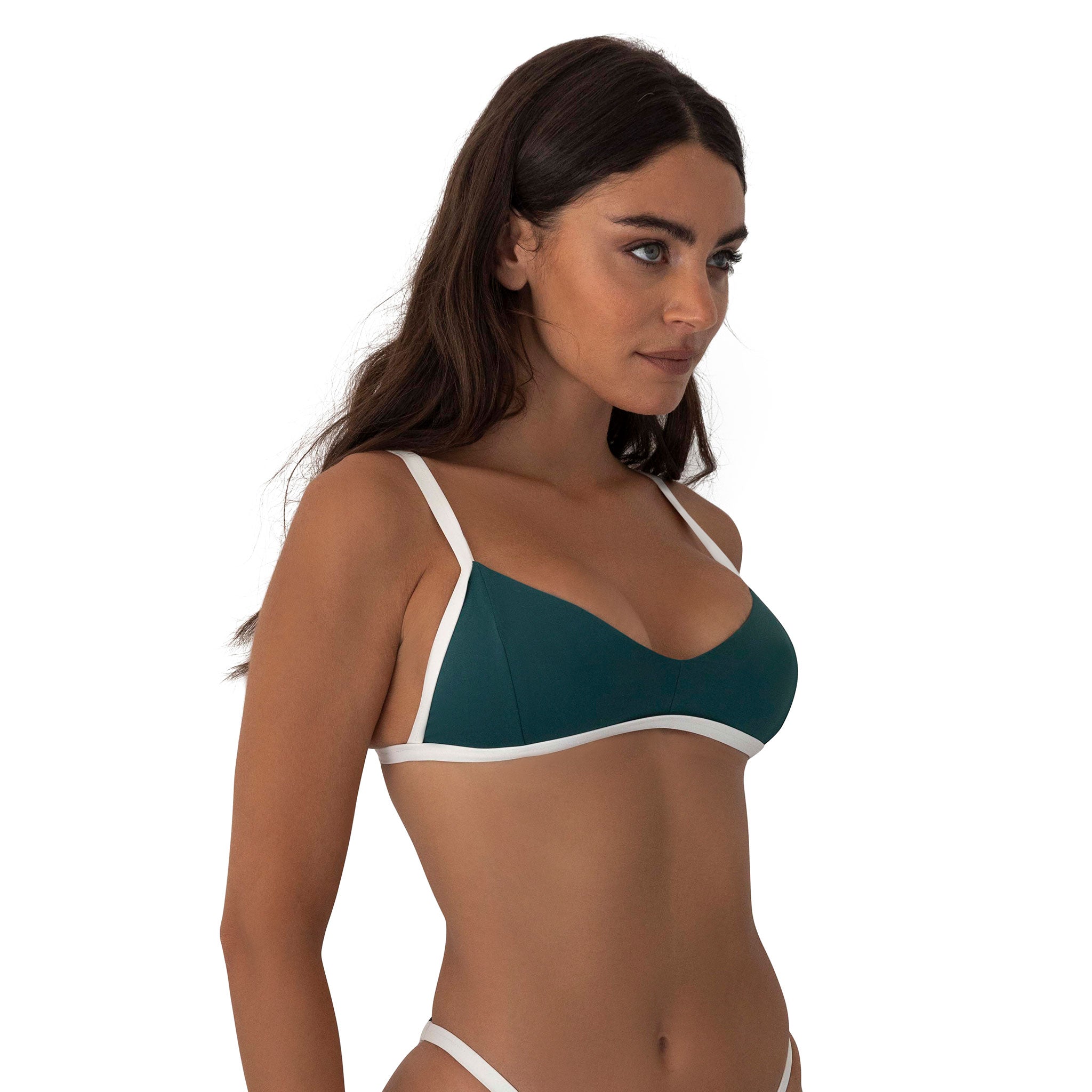 Woman wearing a green bikini top with white straps on a white background