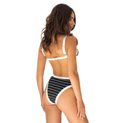 Woman wearing a black and white striped bikini on a white background