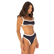 Woman wearing a black and white bikini set on a white background