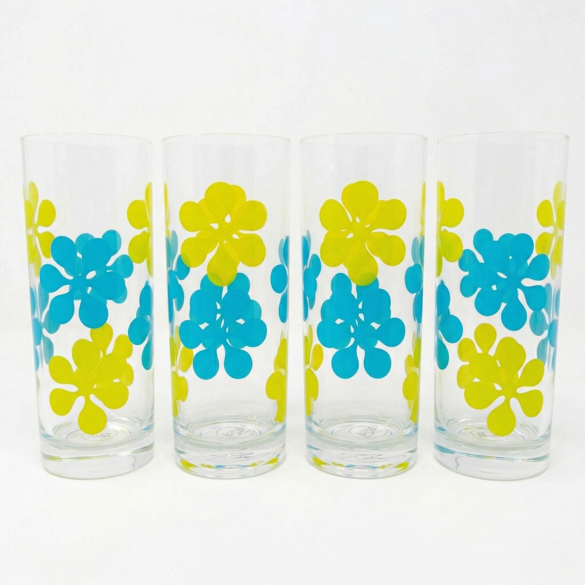 Four glass tumblers with blue and yellow floral patterns on a white background