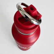 A red insulated water bottle with a matching red lid and a shiny silver metal carrying loop, shown on a plain light background.