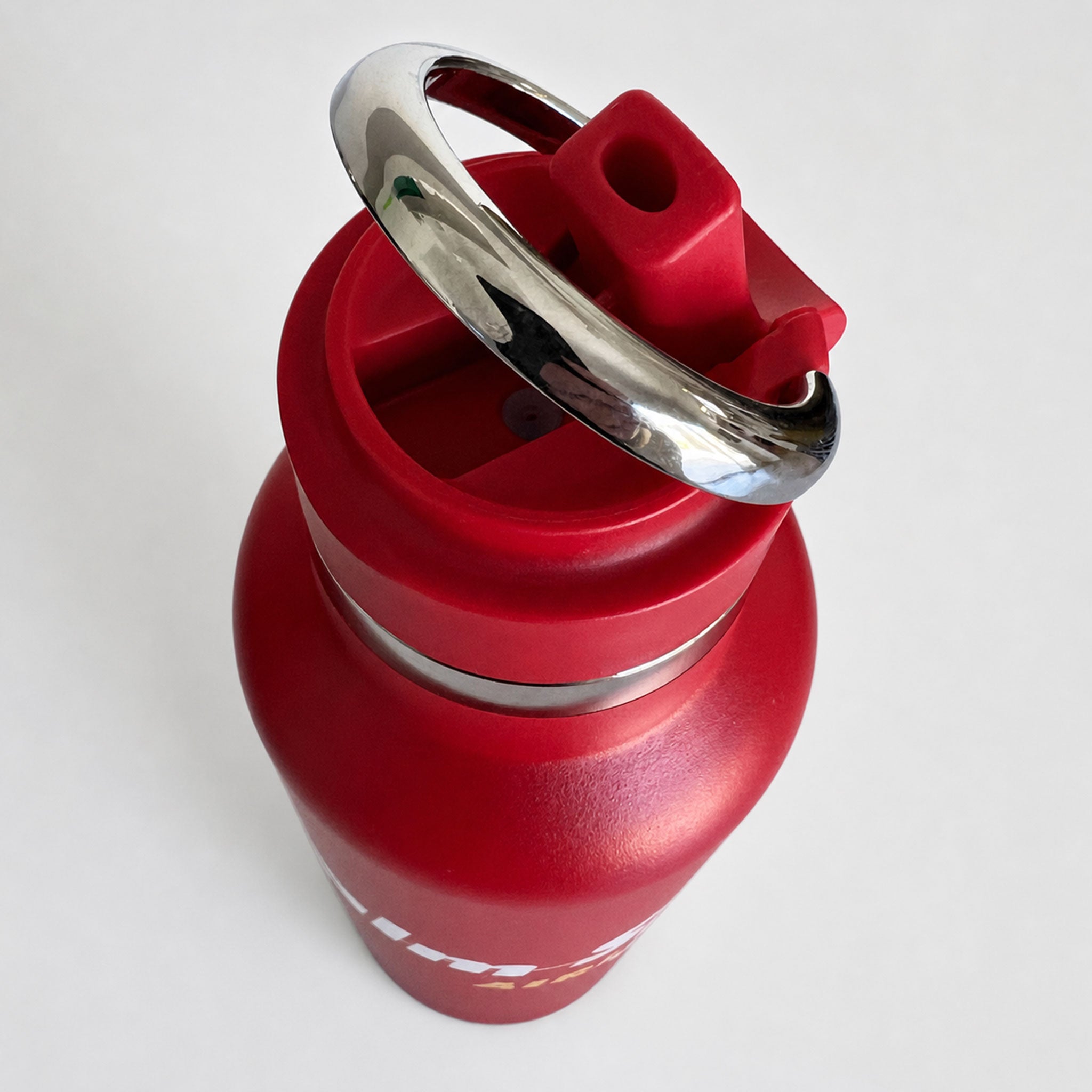 A red insulated water bottle with a matching red lid and a shiny silver metal carrying loop, shown on a plain light background.