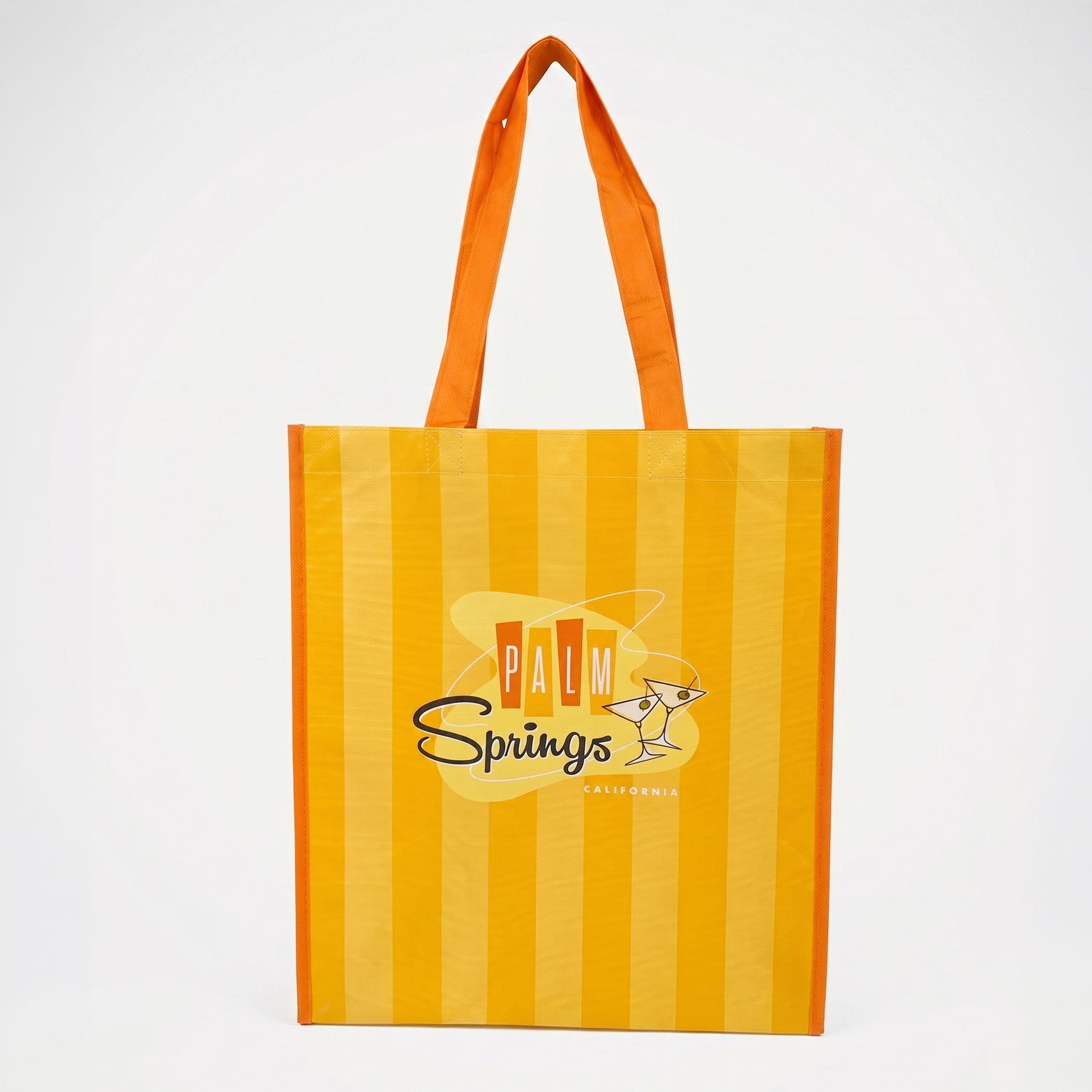 Yellow and orange striped tote bag with 'Palm Springs' logo on a white background
