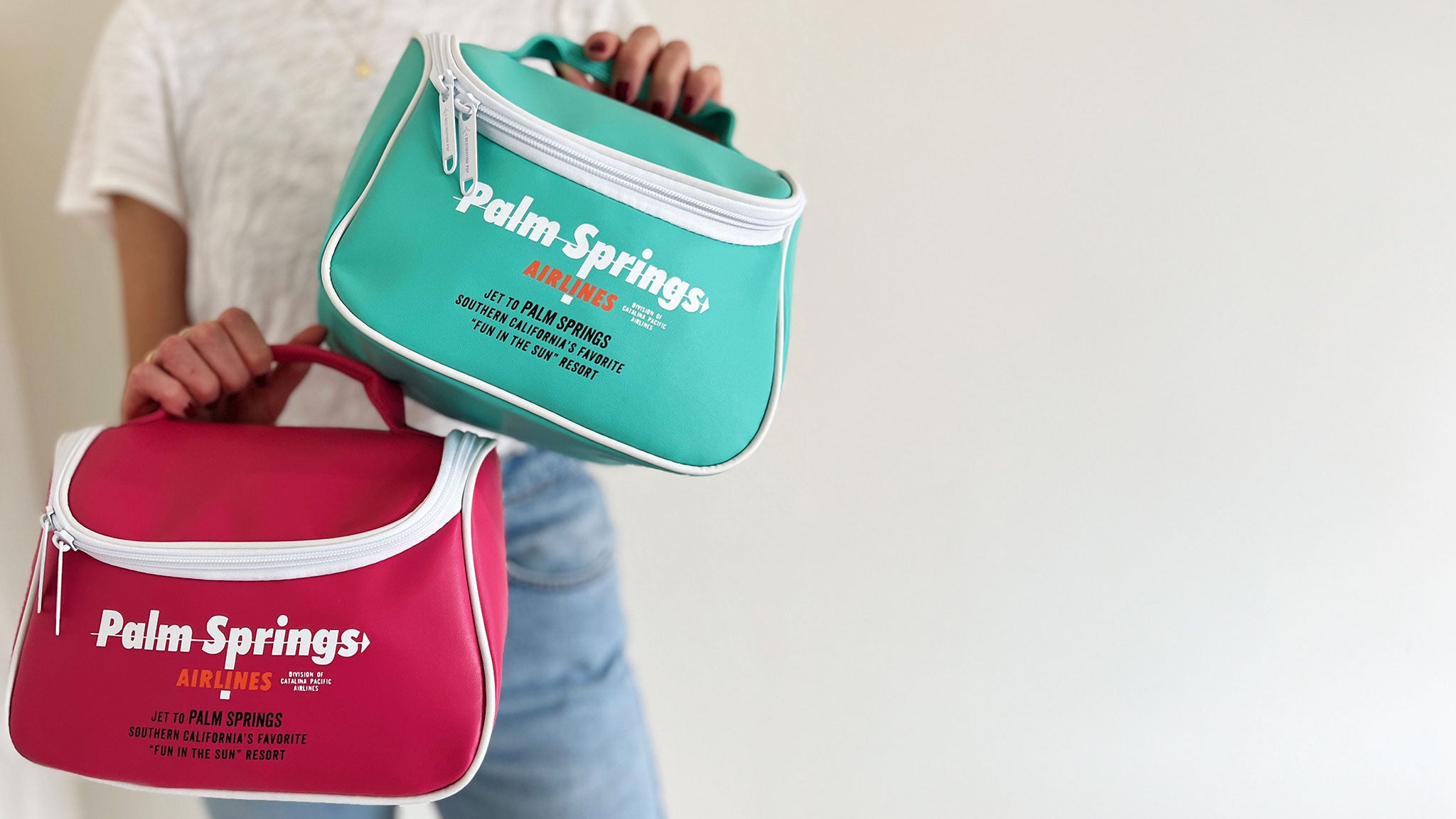 A woman holding retro pink and aqua travel bags